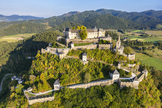 Aerial view of the formidable Hochosterwitz Castle perched atop a verdant hill, a medieval stronghold against a backdrop of rolling mountains, Hochosterwitz, K&Atilde;&curren;rnten, Austria.