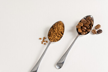 Roasted Coffee beans and instant coffee in spoons. Top view, white background