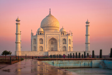 Fototapeta premium Serene Sunrise at the Taj Mahal: Iconic Indian Landmark, Soft Pink Hues, Tranquil Atmosphere, Architectural Detail.