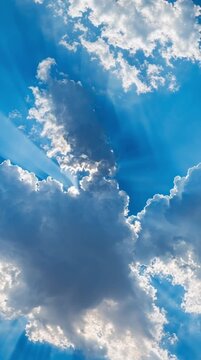 Seamless loop background sky with white fluffy clouds, vertical video of natural blue sky and moving clouds, relaxing atmosphere animation for background and motion design