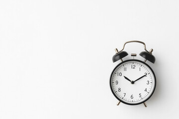 Minimalistic black alarm clock on white background for time concept