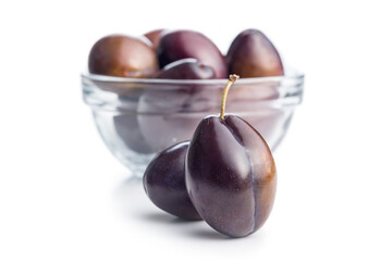 Ripe plums in bowl isolated on white background.