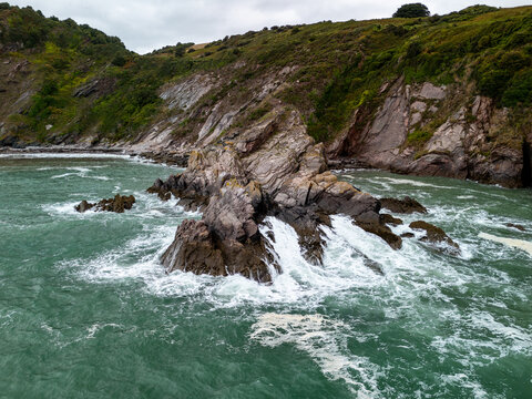 Ocean waves crashing against rocks in a cove on the coast