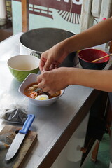a hand is making a cheap street food spicy japanese ramen. Portrait or vertical mode, suitable for social media