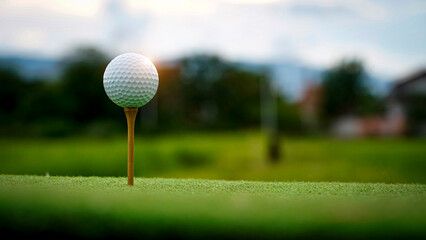 Golf ball on green grass in the evening golf course with sunshine background.