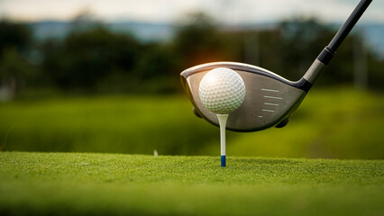Golf ball on green grass in the evening golf course with sunshine background.
