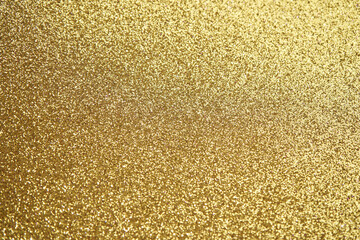 Glittering gold texture sparkles with bright metallic shine and radiant luxury.