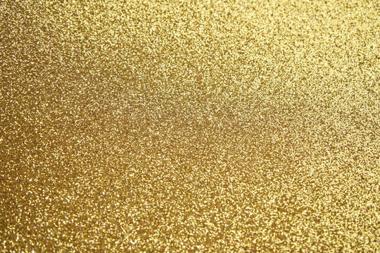 Glittering gold texture sparkles with bright metallic shine and radiant luxury.