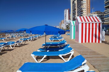 Obraz premium Sunbeds for rent on a sunny day on Levante Beach in Benidorm, Spain.