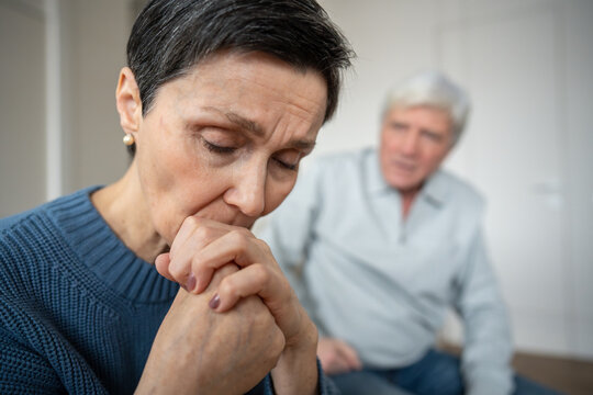Close up depressed sad woman turned away from husband, in emotional withdrawal, hurt feelings. Senior couple discord, marital tension, silent resentment, relationship breakdown, unspoken grievances
