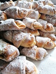 In a row, stacked on top of each other, powdered sugar-coated snow crescents, photographed up close.