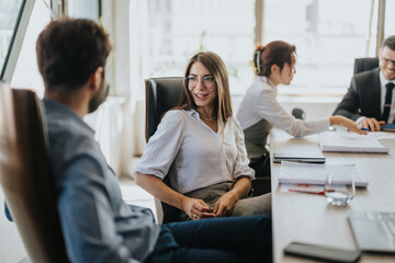 A diverse group of business people during a dynamic meeting in a modern office setting, highlighting teamwork and collaboration. The atmosphere is professional yet relaxed, promoting effective
