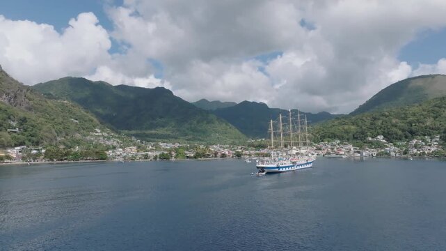 Aerial view of a majestic ship sailing through the calm waters, contrasting with the lush green hills surrounding Le Pitons, Soufri&egrave;re, Saint Lucia.