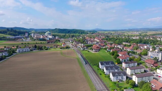 Aerial view of the vibrant landscape, where the sugar factory stands amidst lush greenery, contrasting with the red-roofed houses, Aarberg, Canton of Bern, Switzerland.