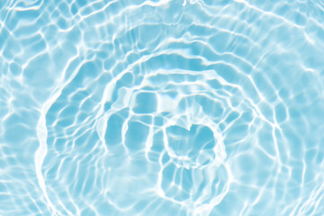 Blue water with ripples on the surface. Defocus blurred transparent blue colored clear calm water surface texture with splashes and bubbles. Water waves with shining pattern texture background.