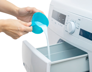 pouring detergent liquid from a measuring cup into a washing machine drawer