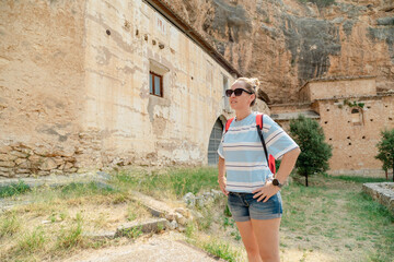 Fototapeta premium Tourist exploring ancient monastery in picturesque landscape