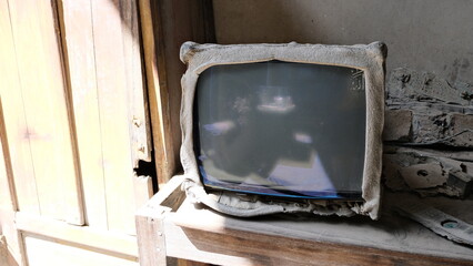 An old television set covered in volcanic ash, damaged and abandoned in a house after Mount...
