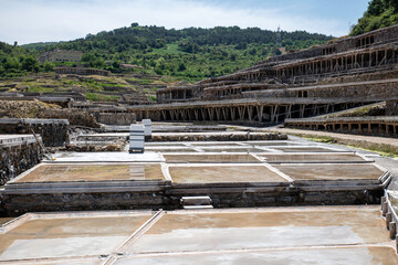 Authentic salt flats showcasing salt winning pools with individuals observing the process