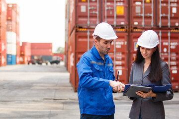 Fototapeta premium Team of engineers or workers at a container yard discussing seriously and shaking hands to symbolize teamwork and business success.
