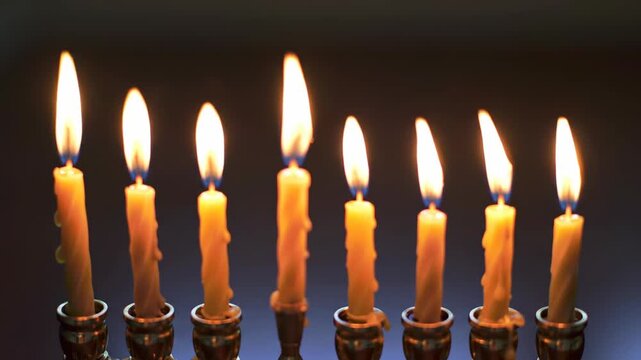 Illuminated candles standing in a row casting soft warm light.