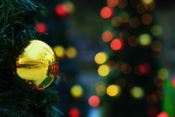 Sparkling Christmas tree lights and gold ball bokeh, December background