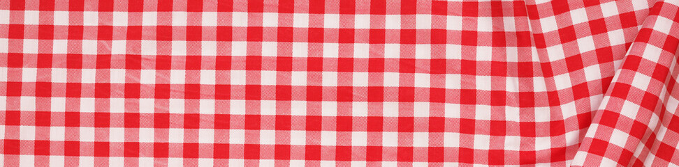 Closeup of a red and white checkered napkin or tablecloth texture. picnic cloth crumpled. Food decor element. Kitchen accessories. Top view background.