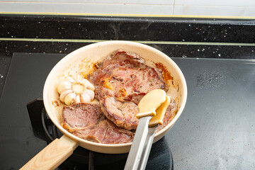 frying two pieces steaks on a pan at home