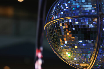 A mirror ball reflecting gold and silver light as a backdrop image for night club party