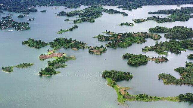 Aerial view of Kaptai Lake shows the serene waters embracing islands with verdant forests, creating a stunning contrast of blue and green, Rangamati, Chittagong Division, Bangladesh.