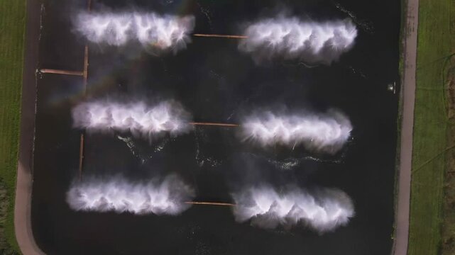Aerial view of inactive spray ponds at Minsk TPP 5, showing rectangular basins, pathways, and surrounding green vegetation in a structured layout.