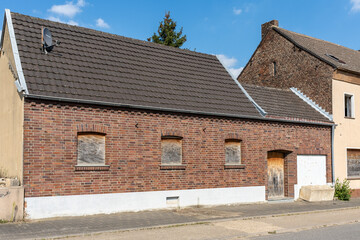 Ziegelhaus mit verbarrikadierten Fenstern und Garagentor, Manheim, NRW, Deutschland