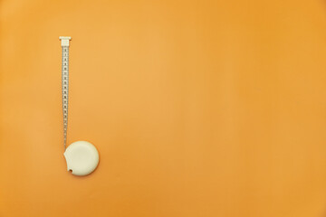 measuring tape on Orange Background, Space for Text, Space for Logo