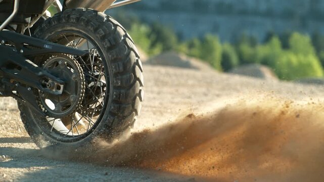 Super slow motion of flying rocks and dust from the wheel of a motocross motorbike at the start of the race