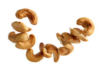 Golden Roasted Cashews Floating in Elegant Spiral Formation on White