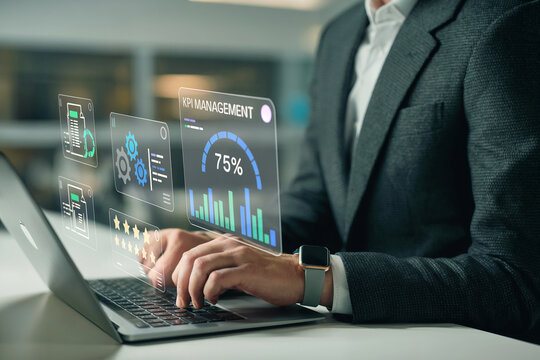 Close-up of sharply dressed professional in suit typing on laptop with glowing financial data hologram overlay
