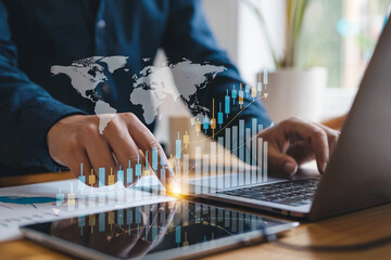 Hands using laptop and tablet with glowing financial data charts and world map overlay for global business analytics and digital marketing strategy