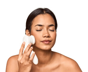 Young Filipino woman using electric facial cleanser