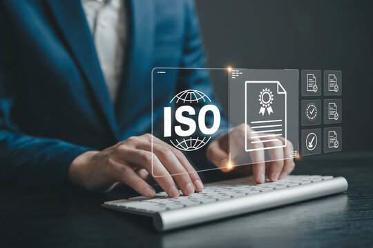 Business professional using a keyboard with iso certification hologram displayed overhead symbolizing quality management and compliance standards achievement in modern office