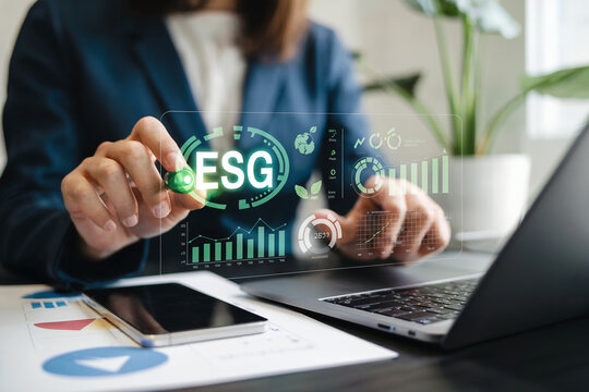 Business professional analyzing esg data on a futuristic digital interface demonstrating sustainable finance and environmental responsibility in a modern office setting.