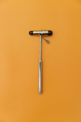 medical hammer and medical needle on Orange Background, Space for Text, Space for Logo