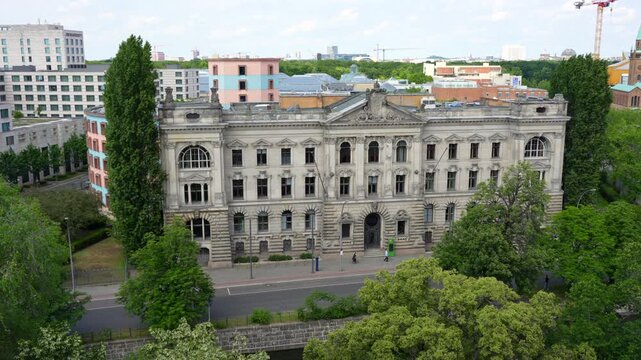 Berlin, Germany - May 31, 2025: Aerial view of a historic social science research building in Berlin, featuring classical architecture, lush trees, walking people and traffic.