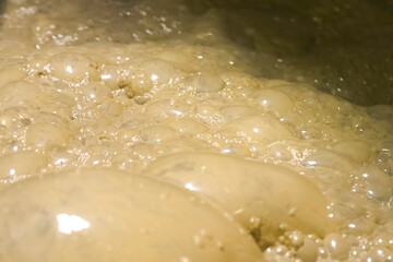 Bubbles of foam in the dirty water of gold ore tank.