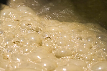 Bubbles of foam in the dirty water of gold ore tank.