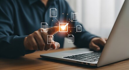A person using a laptop with document icons and a check mark for digital validation and business solutions on a wooden table