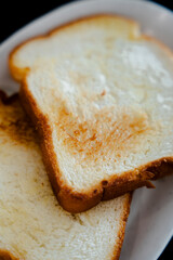 Close-up of two slices of toast, golden brown and lightly buttered, perfect for a simple breakfast.