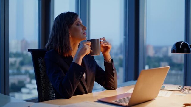 Relaxed entrepreneur drinking coffee at evening workplace closeup. Calm woman - Powered by Adobe