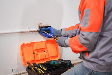 Skilled technician performing maintenance on electrical system while using hand tools and power...