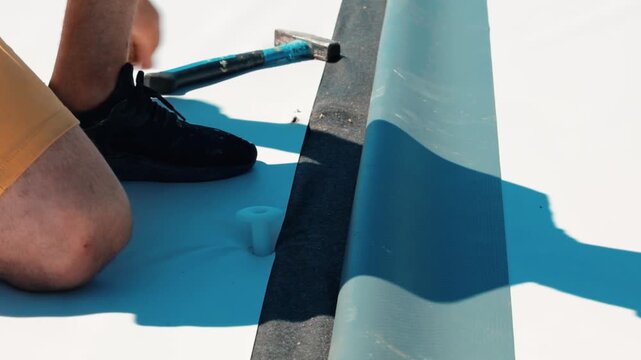 Construction worker installing pvc roofing membrane