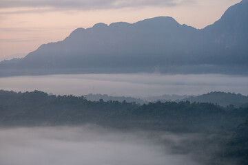 Mountain landscape with morning fog and forest in peaceful natural setting   at  Phadeng Peak, Luang Prabang, Laos